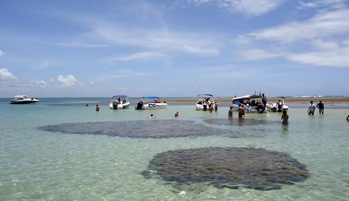 Pessoas e embarcações em águas rasas na Bahia